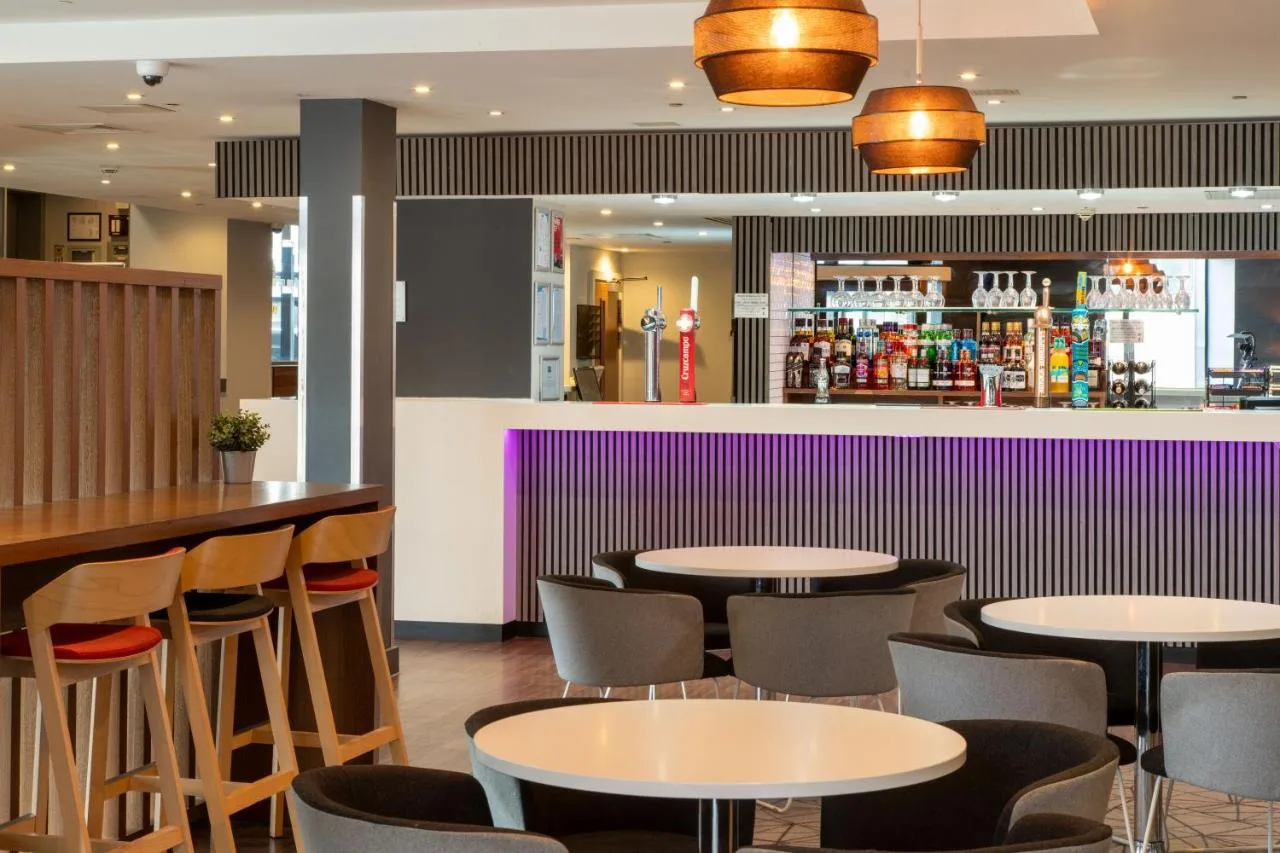 a restaurant with tables and chairs and a bar at Holiday Inn Express Birmingham - Snow Hill by IHG in Birmingham