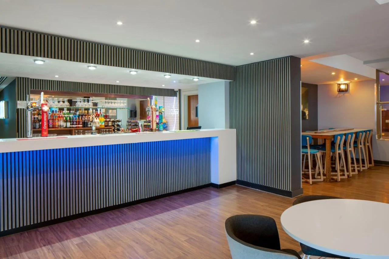 a bar in a restaurant with tables and chairs at Holiday Inn Express Birmingham - Snow Hill by IHG in Birmingham