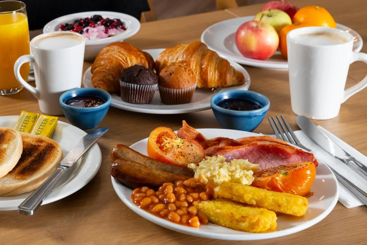 a table with plates of breakfast food on it at Holiday Inn Express Birmingham - Snow Hill by IHG in Birmingham